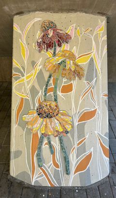 I mosaikarbetet är solhattblommor i gula och bruna nyanser avbildade.