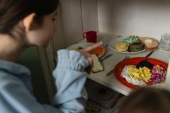 Ihminen katsoo hyllyllä olevia kouluruoka-annoksia.