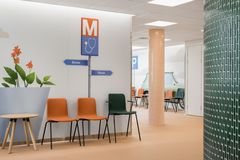 Espoonlahden terveysaseman käytävä, jossa seinällä kuvia ja edustalla tuoleja.