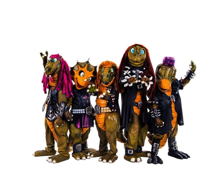 viisi muusikkoa pukeutunut dinosauruksiksi.