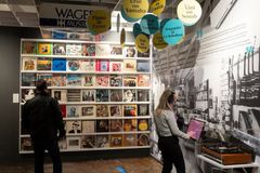 Kaksi ihmistä seisoo vinyylilevykansien edessä.