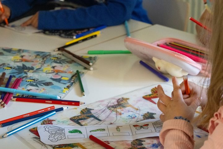 Ett barn gör uppgifter vid ett bord.