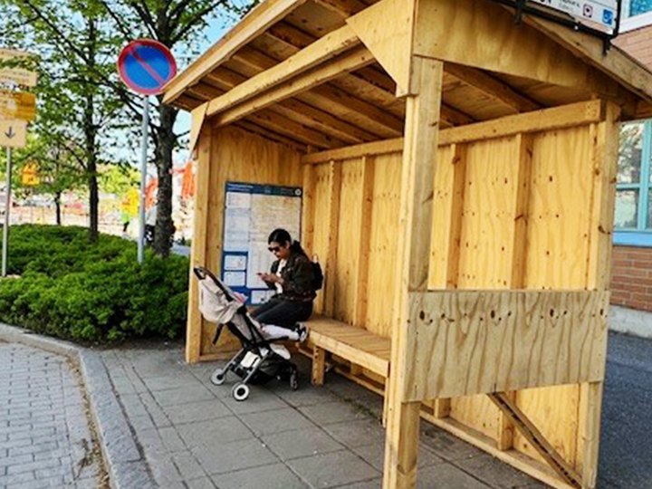 The picture shows a temporary bus stop made of wood.