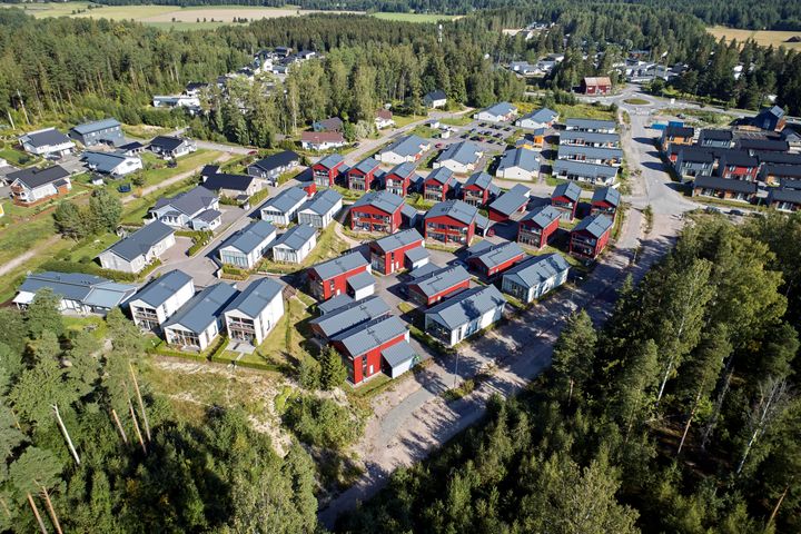 Ilmakuva, jossa näkyy pientaloja, puita, teitä ja peltoja.