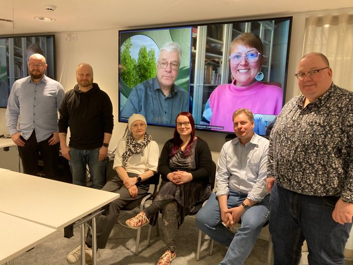 Av-käännösalan neuvottelijat yhteiskuvassa. Vasemmalta Jukka Sorsa, Janne Kauppila, Hanna Gorschelnik, Marketta Hakkarainen, Jaakko Sauvola ja Petri Savolainen sekä etäyhteydellä neuvotteluun osallistuneet Mikko Lyytikäinen ja Annika Karvonen. Kuva: Marja Honkonen, Journalistiliitto.