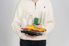 Henkilö pitää käsissään erilaisia muovipakkauksia, kuten pulloja ja rasioita.