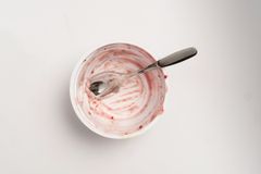 Tyhjä muovinen jogurttipurkki, jossa on lusikka.