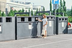 Henkilö vie roskia Rinki-ekopisteelle kierrätettäväksi.