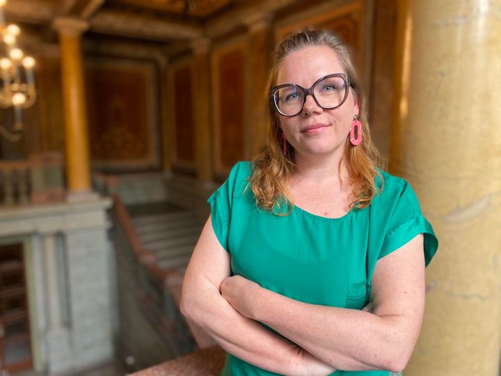 Maija Koivisto nojaa pylvääseen yllään vihertävä paita.