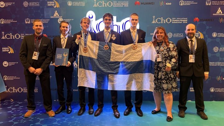 Suomen delegaatio IChO:n palkintojenjaon jälkeen: Vasemmalta oikealle Jukka Puumi, Nicolas Tallbacka, Atso Erkkilä, Michael Christodoulou, Joonas Kuosa, Juulia Talvitie ja Kjell Knapas.  Michael Christodouloulla on rintataskussaan joukkueen maskotti, liito-orava Natalia.