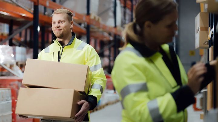 Kaksi henkilöä työskentelee varastolla.
