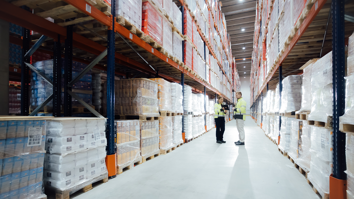 Henkilöitä suurella logistiikkavarastolla.