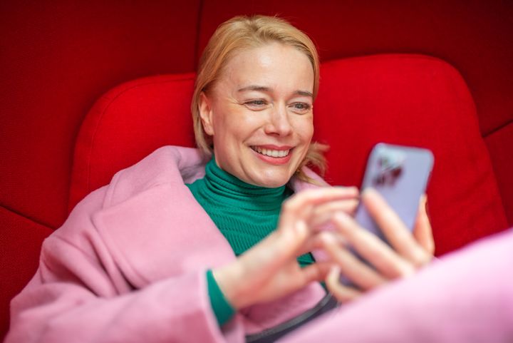 Kvinnan tittar på sin mobiltelefon.