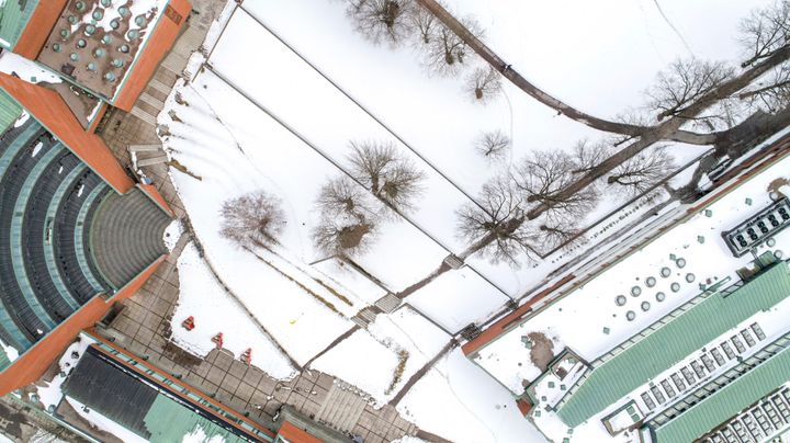 Aalto-yliopiston Kandidaattikeskus ylhäältä talvella. Kuvassa näkyy kevyt lumipeite, josta erottuu rakennusten väliset polut.