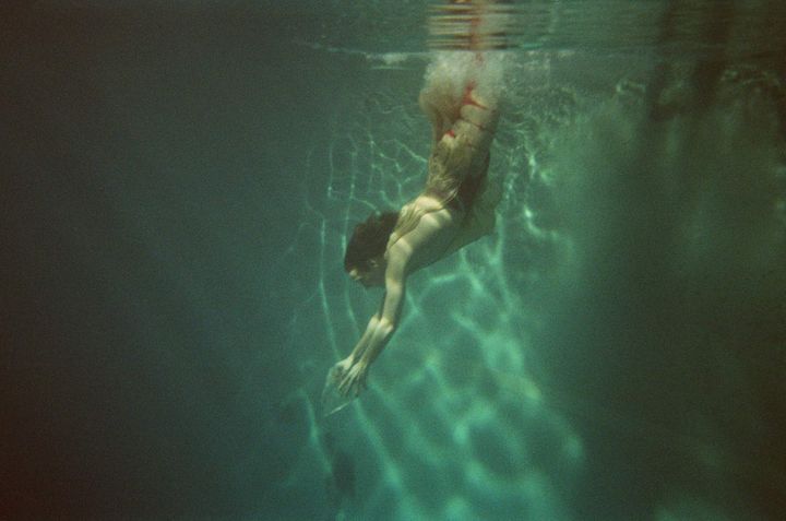 Ihminen sukeltaa veden alla niin, etteivät hänen jalkansa näy.