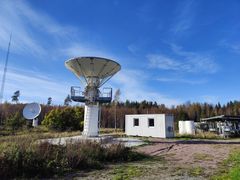 Kaksi radioteleskooppia osoittaa suoraan ylöspäin syksyisessä maisemassa.