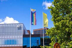 Aalto-yliopiston kampuksella liehuu sateenkaarilippu ja Aalto-yliopiston lippu aurinkoisena päivänä.
