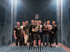 Group of people with one holding a small satellite