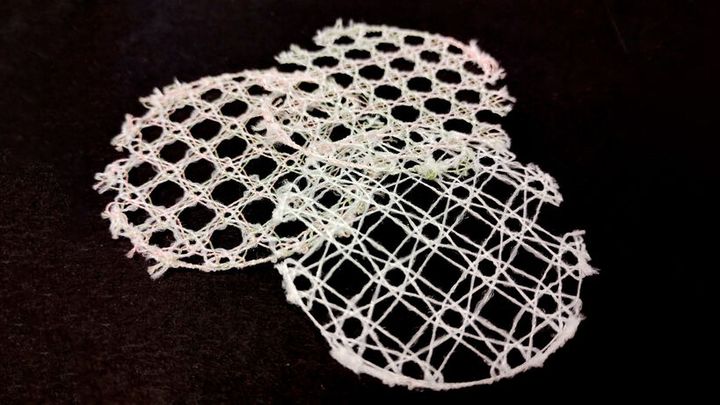 Kolme pyöreää, pitsimäistä kekoa herkän verkkomaisella kuviolla mustalla taustalla.