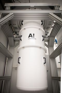 Suuri, valkoinen sylinterimäinen laite, jossa on Aalto-yliopiston logo.