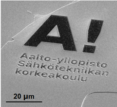 Kuva mikroskooppikuvasta, joka näyttää Aalto-yliopiston Sähkötekniikan korkeakoulun logon, tehty atomisen ohuilla materiaaleilla.