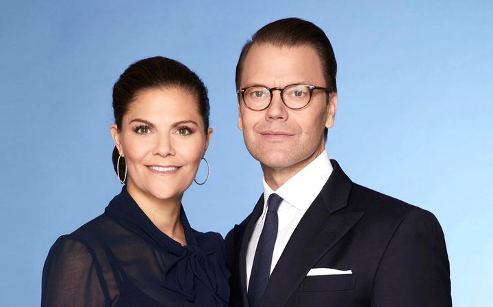 Valokuva kahdesta henkilöstä poseeraamassa yhdessä muodollisissa vaatteissa.