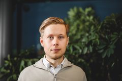 Miika Manun kasvokuva, taustalla viherkasveja.