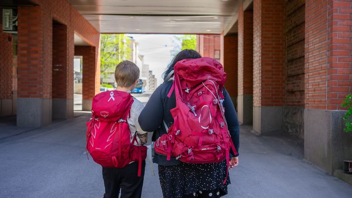 Kaksi punareppuista henkilöä kävelee porttikongissa.