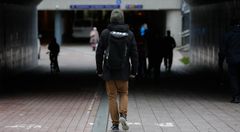 Reppuselkäinen henkilö kävelee tunnelissa.