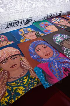 Maalauksia levitettynä pöydälle.