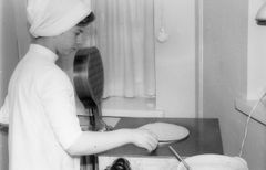 Leipomotyöntekijä paistaa leipälevyä vanhalla pannulla.