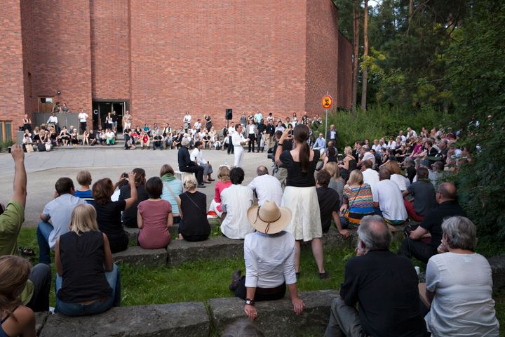Seminaariyleisöä Jyväskylän yliopiston päärakennuksen piha-alueen amfikatsomossa.