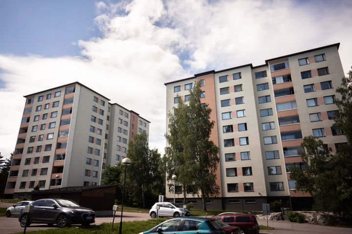 Kaksi kerrostaloa, joiden edustalla on autoja parkkipaikalla.