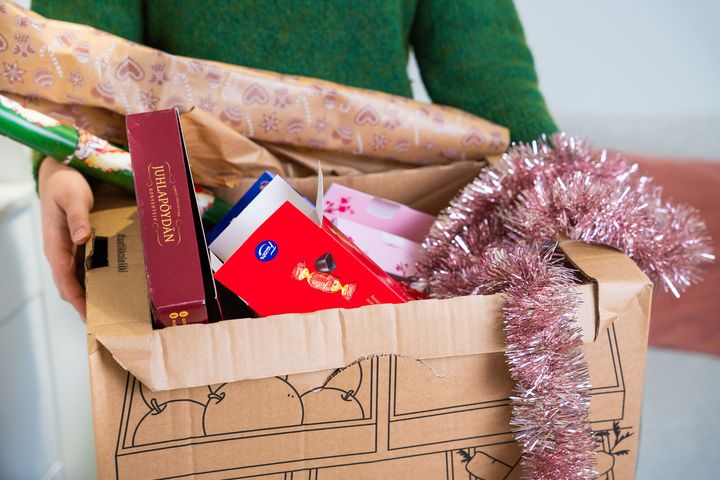Pahvilaatikossa on kartonkijätettä, joulukoristeita ja lahjapaperia.