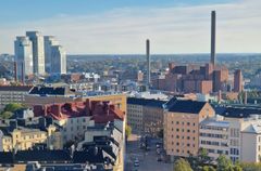 Näkymä kaupungista, jossa näkyy kerrostaloja ja energialaito.