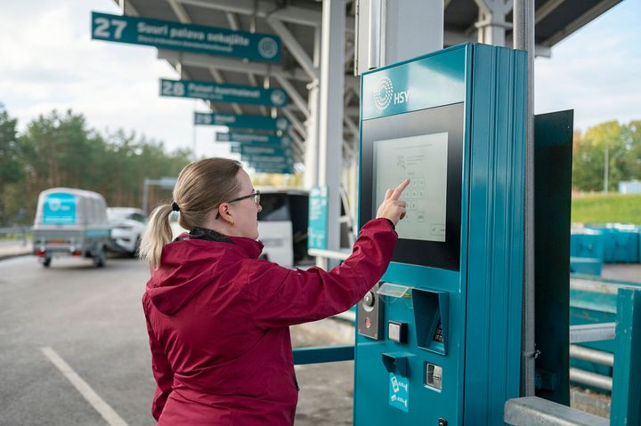 Sortti-aseman asiakas näppäilee itsepalvelulaitetta.