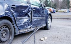 Henkilöauto, jonka kylki on rutussa törmäyksen jäljiltä.