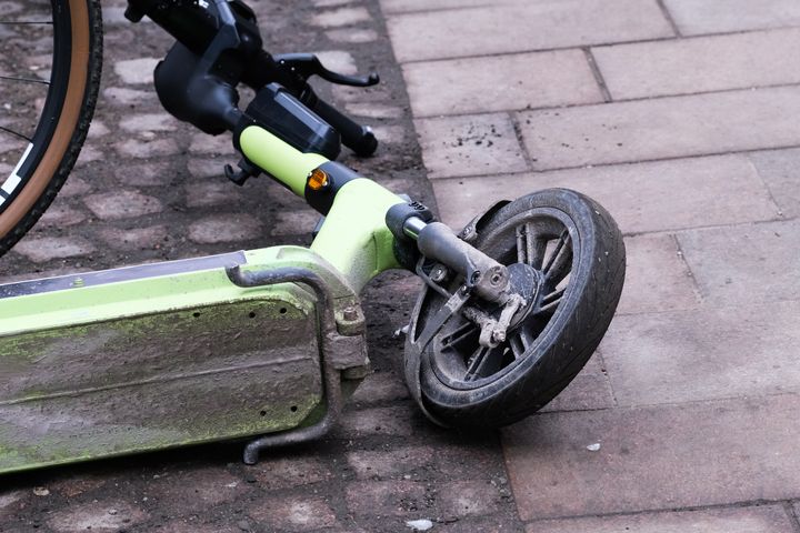 Kaatunut sähköpotkulauta jalkakäytävällä.