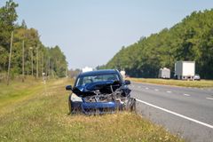 Kolaroinut henkilöauto valtatien pientareella.
