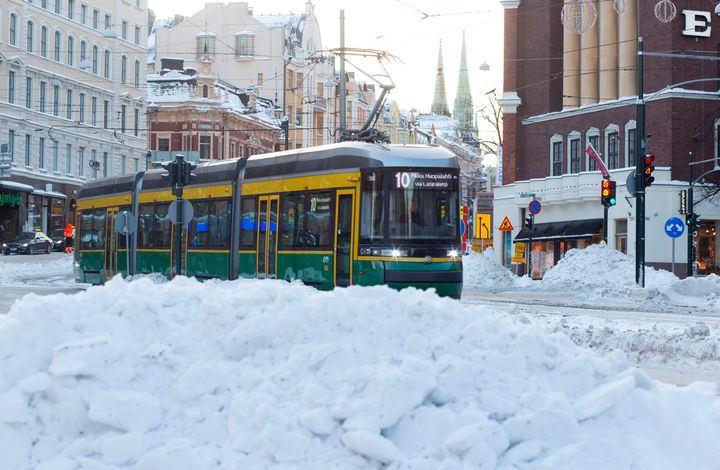 Raitiovaunu linjalla numero 10 lumisessa maisemassa Helsingin Erottajalla