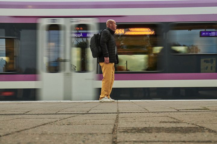 Ihminen asemalaiturilla, taustalla HSL:n juna