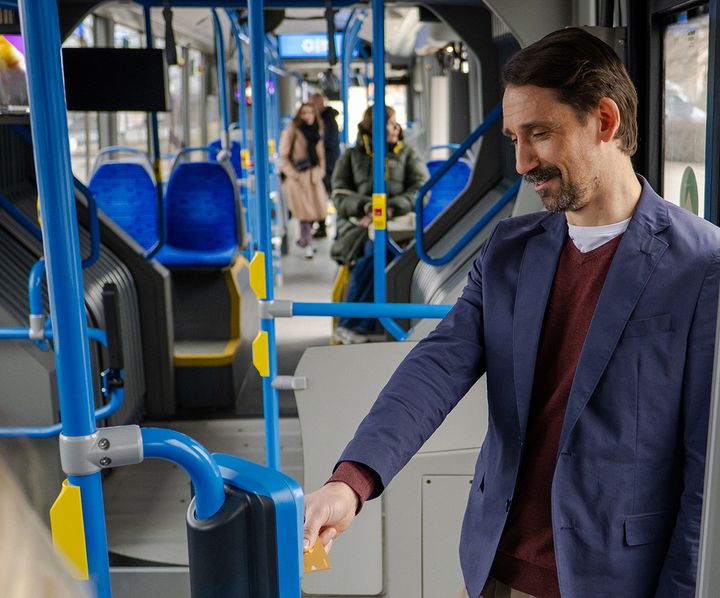 Mies bussissa näyttää korttia lukijalle