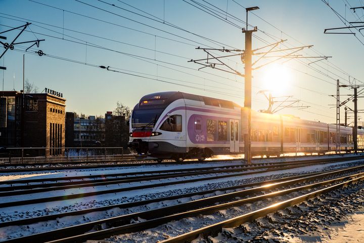 Juna raiteilla, taustalla auringonpaiste