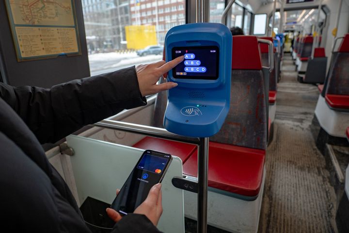 Matkustaja raitiovaunussa valitsemassa vyöhykkeitä kertalipun ostamiseksi lähimaksulla