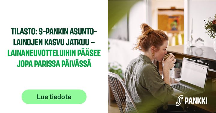 Nainen käyttää kannettavaa tietokonetta ja juo kahvia keittiössä. Kuvassa S-Pankin teksti asuntolainojen kasvusta.