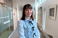 Mari Govenius, kreditchef vid S‑Banken. Personen står i en kontorskorridor och bär en ljusblå blus med dekorativa volanger och svarta band.