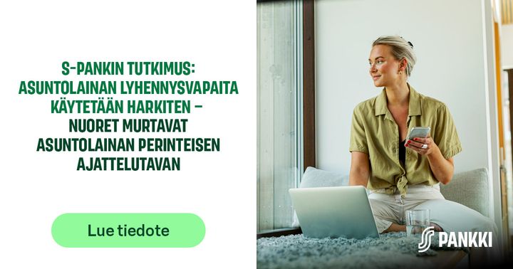 Henkilö istuu kotona ikkunan äärellä kannettavan tietokoneen kanssa ja pitää kädessään puhelinta, moderni ja valoisa työskentely-ympäristö.