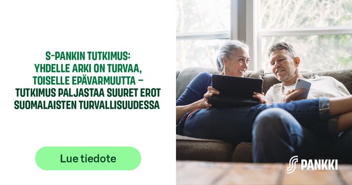 Kaksi aikuista istuu sohvalla kotona ja käyttää tablettia ja älypuhelinta.