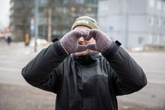 Henkilö tekee lapasilla sydämen muotoista elettä keskustassa.