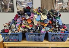 Kolme laatikkoa täynnä värikkäitä villasukkia.